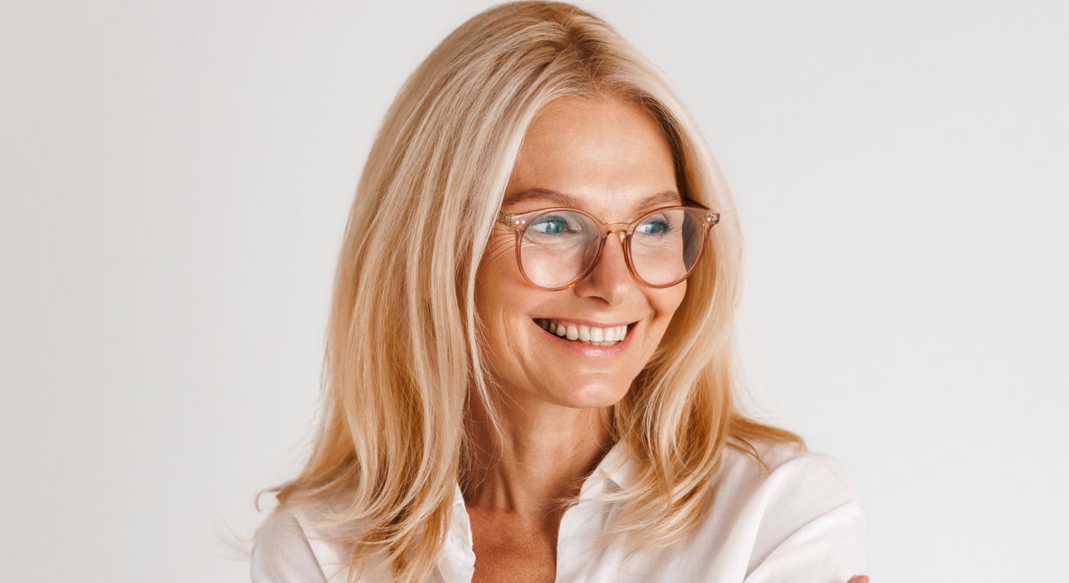 Smiling woman with glasses and long blonde hair.